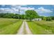 Property featuring a long driveway leading to a well-maintained house surrounded by lush greenery at 9161 Paul Payne Store Rd, Stony Point, NC 28678