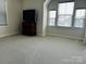 Bright bedroom features neutral carpet, three windows, and a television, creating a comfortable living space at 934 Prince Garrett Way, Denver, NC 28037