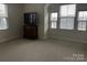 Bedroom with ample natural light, featuring a dark wood cabinet and view of neighborhood homes at 934 Prince Garrett Way, Denver, NC 28037