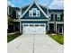 Charming townhouse displaying blue siding, stone accents, and a pristine white garage door at 934 Prince Garrett Way, Denver, NC 28037