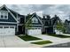 Charming blue townhomes boast white garage doors, stone accents, and well-manicured landscaping at 934 Prince Garrett Way, Denver, NC 28037