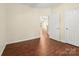 Bedroom with hardwood flooring, neutral walls, and open doorway leading to other rooms at 9430 Duckhorn Dr, Charlotte, NC 28277