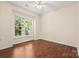 Bedroom with ceiling fan, hardwood floors, and large bright windows with backyard view at 9430 Duckhorn Dr, Charlotte, NC 28277