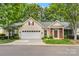 Charming home with attached two-car garage, brick entryway, and lush green lawn at 9430 Duckhorn Dr, Charlotte, NC 28277