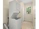Stacked washer and dryer in laundry closet with tile floor at 9430 Duckhorn Dr, Charlotte, NC 28277