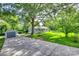 Front exterior of the home featuring a paved driveway, lush green grass, and mature trees at 983 Willowbrook Ave, Rock Hill, SC 29730