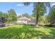 Expansive backyard featuring a well-maintained lawn, in-ground pool, and mature trees at 10338 Hollybrook Dr, Charlotte, NC 28277
