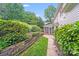 Beautifully landscaped backyard with a stone pathway leading to the screened-in porch at 10338 Hollybrook Dr, Charlotte, NC 28277