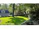 Expansive backyard with mature trees and a swing, perfect for outdoor recreation and relaxation at 10338 Hollybrook Dr, Charlotte, NC 28277