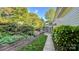 Landscaped backyard featuring a well-manicured lawn, mature trees, and a cozy screened-in porch at 10338 Hollybrook Dr, Charlotte, NC 28277