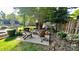 Outdoor living space featuring a stone fire pit and chairs surrounded by lush landscaping at 10338 Hollybrook Dr, Charlotte, NC 28277