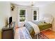 Cozy bedroom with two windows, wood floors, ceiling fan and decorative rug at 10338 Hollybrook Dr, Charlotte, NC 28277