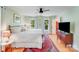 Bright bedroom with wood floors, ceiling fan, windows and a red area rug at 10338 Hollybrook Dr, Charlotte, NC 28277