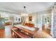 Open dining area with hardwood floors, a long wooden table, and decorative chandelier with an adjacent kitchen at 10338 Hollybrook Dr, Charlotte, NC 28277