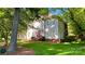 Charming two-story home with a red front door, lush lawn, and mature trees surrounding the property at 10338 Hollybrook Dr, Charlotte, NC 28277