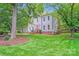 Charming two-story home featuring a well-manicured lawn and vibrant green trees on a sunny day at 10338 Hollybrook Dr, Charlotte, NC 28277