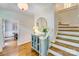 Elegant foyer with hardwood floors, wainscoting, staircase, and decorative cabinet with a round mirror at 10338 Hollybrook Dr, Charlotte, NC 28277