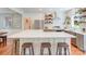 Modern kitchen boasts a large island with seating, stainless steel appliances, and open shelving at 10338 Hollybrook Dr, Charlotte, NC 28277
