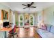 Bright home office featuring hardwood floors, a modern desk setup, and a comfortable sofa at 10338 Hollybrook Dr, Charlotte, NC 28277