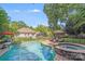 Sparkling in-ground pool and spa with waterfall features, surrounded by lush landscaping at 10338 Hollybrook Dr, Charlotte, NC 28277