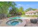 Inviting in-ground pool and spa with brick surround and mature trees offering privacy at 10338 Hollybrook Dr, Charlotte, NC 28277