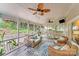 Relaxing screened porch featuring wicker furniture, ceiling fans, and serene backyard views at 10338 Hollybrook Dr, Charlotte, NC 28277
