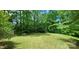 A well-manicured lawn is surrounded by lush green trees, creating a private backyard oasis with an outdoor table set at 1061 Nw 14Th Avenue Nw Dr, Hickory, NC 28601