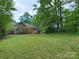 Spacious backyard with a lush lawn, mature trees, and a brick home featuring a wood deck perfect for outdoor entertaining at 1061 Nw 14Th Avenue Nw Dr, Hickory, NC 28601