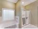 Bright bathroom featuring a glass-enclosed shower and a relaxing soaking tub under a glass block window at 1061 Nw 14Th Avenue Nw Dr, Hickory, NC 28601