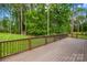Wooden deck overlooks a well-manicured lawn and forest with a shed in the distance at 107 Blue Ridge Trl, Mooresville, NC 28117