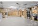 Unfinished basement with concrete flooring and exposed pipes with lighting and wooden supports at 107 Blue Ridge Trl, Mooresville, NC 28117