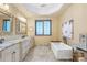 Luxurious bathroom featuring a soaking tub, granite countertops, chandelier, and natural light from the window at 107 Blue Ridge Trl, Mooresville, NC 28117