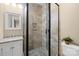 Modern bathroom with a tiled shower featuring glass door, pebble flooring, and a stylish sink and vanity at 107 Blue Ridge Trl, Mooresville, NC 28117