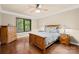 Comfortable bedroom with hardwood floors, a ceiling fan, and a dresser next to a large window with green views at 107 Blue Ridge Trl, Mooresville, NC 28117
