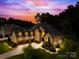 Elegant home with a three-car garage, lit windows, and landscaped grounds at twilight at 107 Blue Ridge Trl, Mooresville, NC 28117