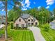 Beautiful brick home with lush landscaping and a long driveway leading to a three-car garage at 107 Blue Ridge Trl, Mooresville, NC 28117