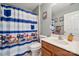 Bright bathroom features a vanity with a wooden cabinet and playful truck themed shower curtain at 108 N Arcadian Way, Mooresville, NC 28117