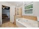 Bright bathroom with tiled jacuzzi tub under a chandelier and walk-in shower at 108 N Arcadian Way, Mooresville, NC 28117