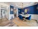 Bright dining room featuring blue accent wall, white wainscoting, and a modern chandelier at 108 N Arcadian Way, Mooresville, NC 28117