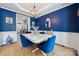 Elegant dining room with blue walls, a white table, and stylish blue velvet chairs at 108 N Arcadian Way, Mooresville, NC 28117