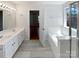 Well-lit bathroom with double vanities, a soaking tub, and a neutral color scheme creating a serene atmosphere at 1184 Lempster Nw Dr, Concord, NC 28027