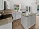 Well-lit kitchen featuring white cabinets, an island, granite countertops, and stainless steel appliances at 1184 Lempster Nw Dr, Concord, NC 28027