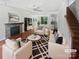 Bright living room with wood floors, fireplace, and stylish furniture arranged around a modern rug at 1184 Lempster Nw Dr, Concord, NC 28027