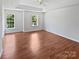 Spacious main bedroom featuring hardwood floors, ceiling fan, and abundant natural light from the windows at 1184 Lempster Nw Dr, Concord, NC 28027