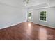 Open main bedroom with tray ceiling, large windows, and hardwood flooring at 1184 Lempster Nw Dr, Concord, NC 28027