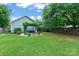 Expansive backyard featuring a vine-covered pergola, fire pit area, and lush green lawn, perfect for entertaining at 1201 Pegram St, Charlotte, NC 28205