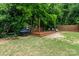 Backyard with wood deck, seating, grill, and lush trees providing a private outdoor space at 1201 Pegram St, Charlotte, NC 28205