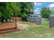 Landscaped backyard features a wooden deck, gravel area, partial fence, small shed, and lush trees at 1201 Pegram St, Charlotte, NC 28205
