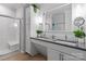 Bathroom featuring double sinks, white cabinets, a walk-in shower, and greenery at 1201 Pegram St, Charlotte, NC 28205