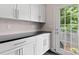Mudroom with white cabinets, black countertops, and a door leading to the outside at 1201 Pegram St, Charlotte, NC 28205